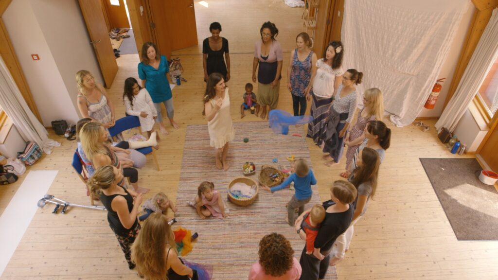 A circle of women and children in a singing mamas session